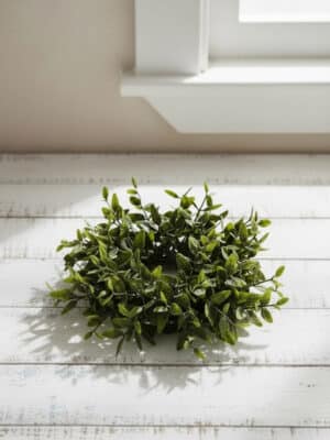 Lemon Beauty taper candle ring, 5 inches, featuring layered green leaves in soft and deep tones on a white tabletop near a window.