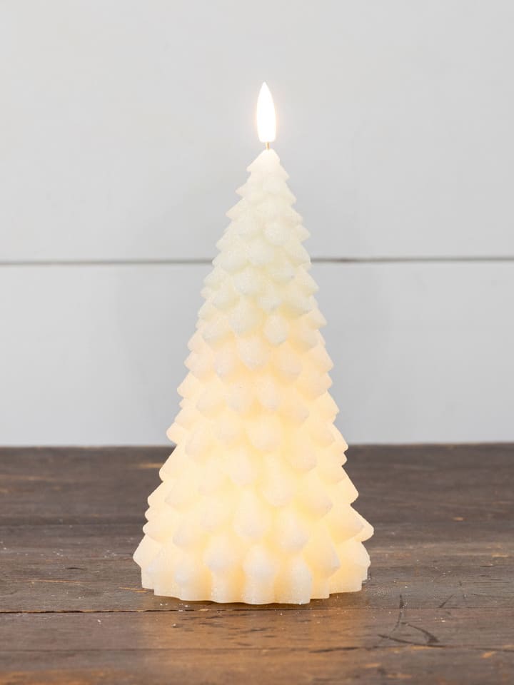 Cream 3D fir tree flameless candle glowing softly on a wooden surface