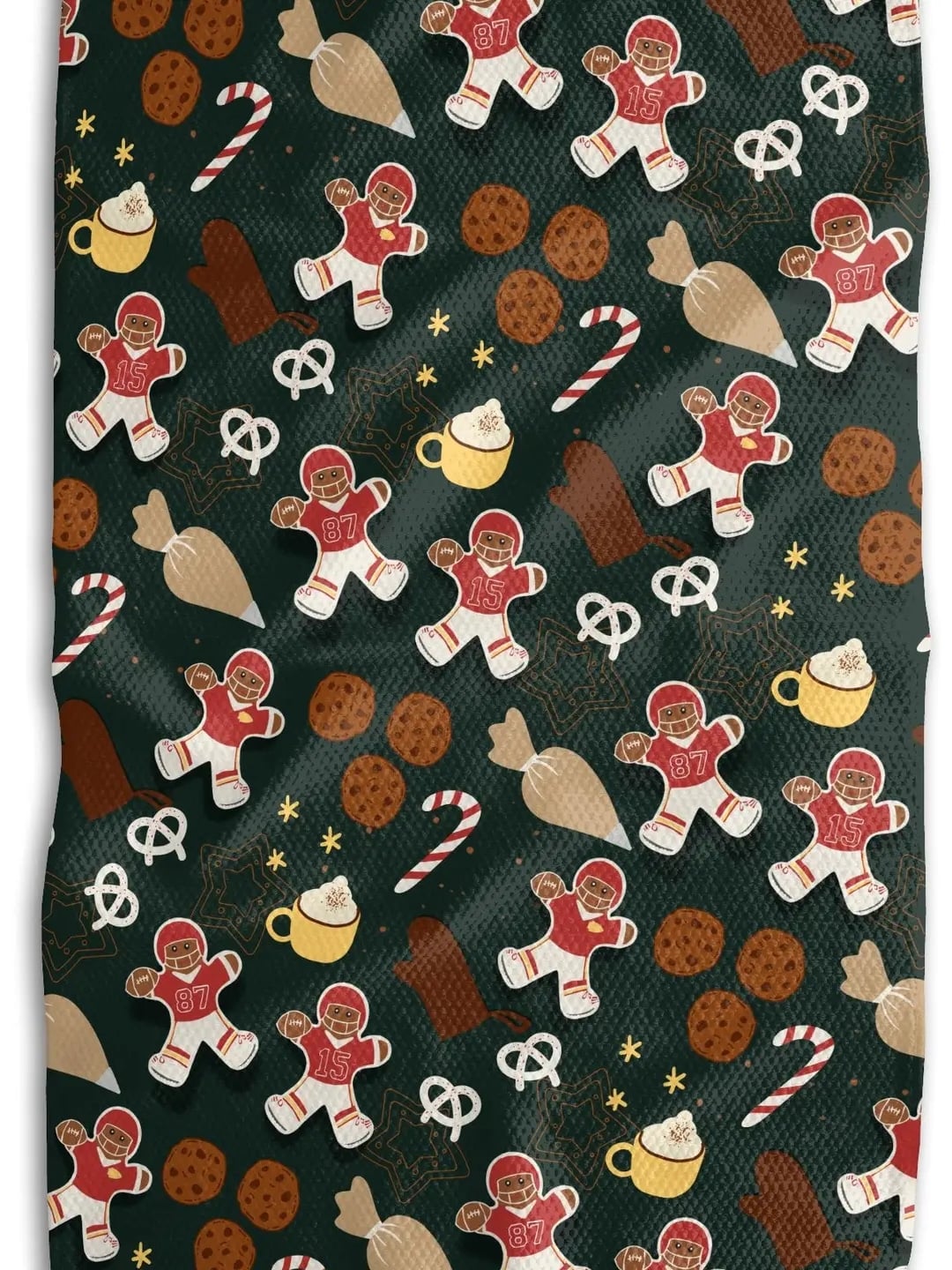 Chiefs Christmas Cookies Tea Towel with gingerbread players, cookies, candy canes, and cocoa mugs on green background.