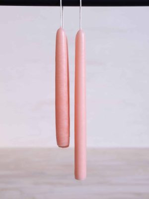 Peach Blossom hand-dipped taper candles in a soft blush tone, shown hanging.