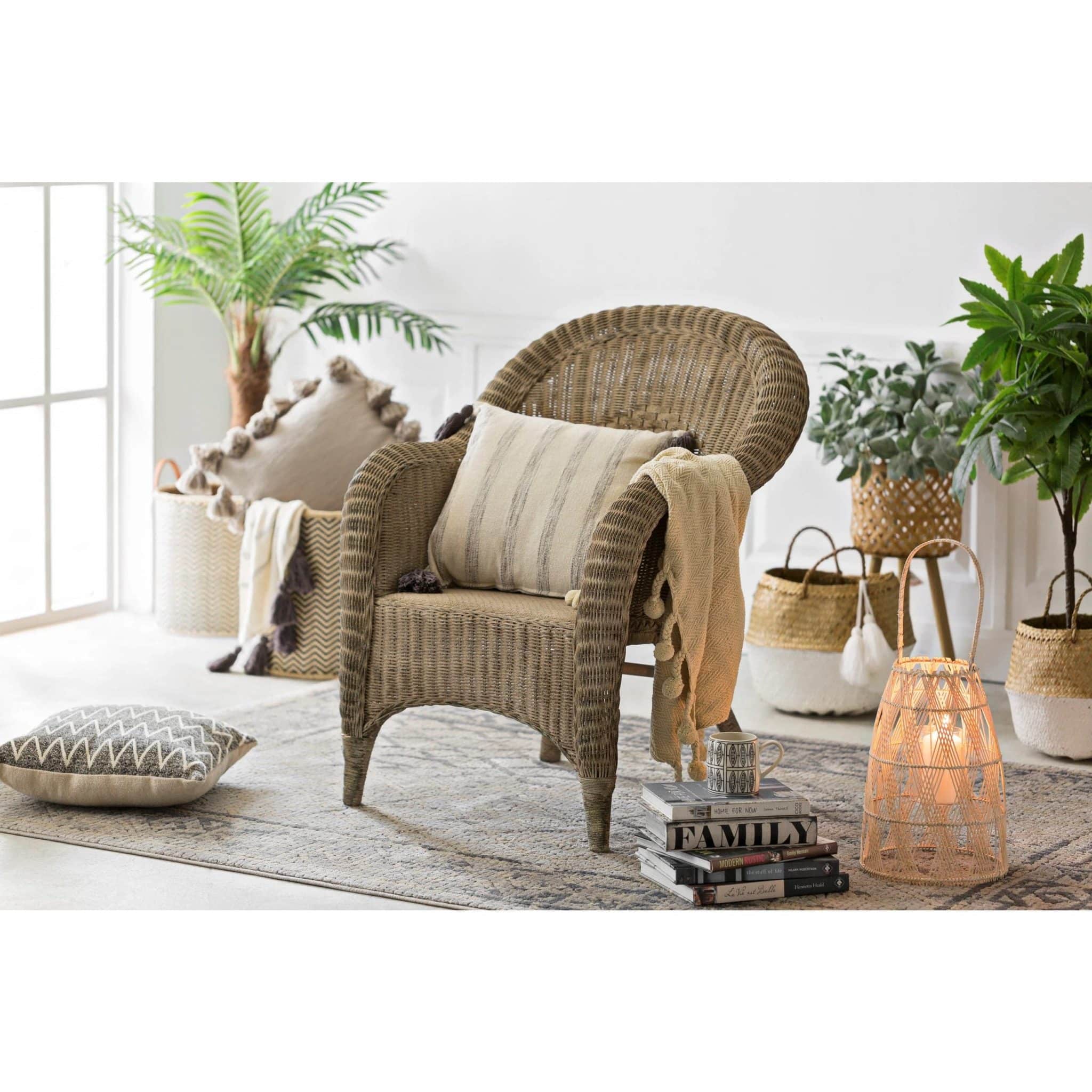 Large bamboo lantern styled beside a wicker chair in a cozy, sunlit room.