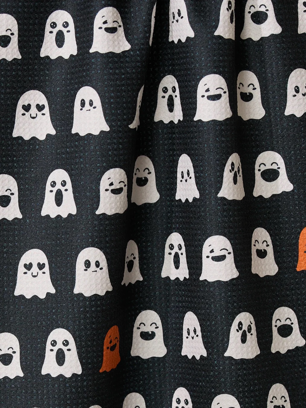 Black Geometry kitchen towel decorated with expressive ghost faces and orange accents.