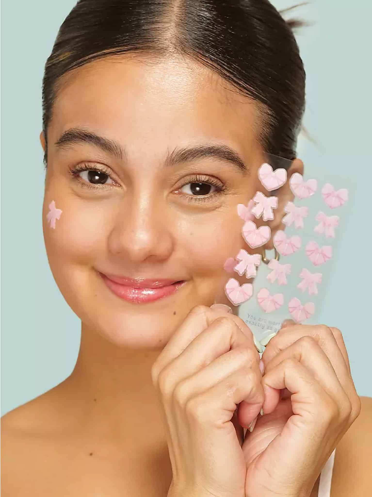 Girl wearing Pretty in Pink Bow Pimple Patches with pink bow and bow heart hydrocolloid acne patches on face