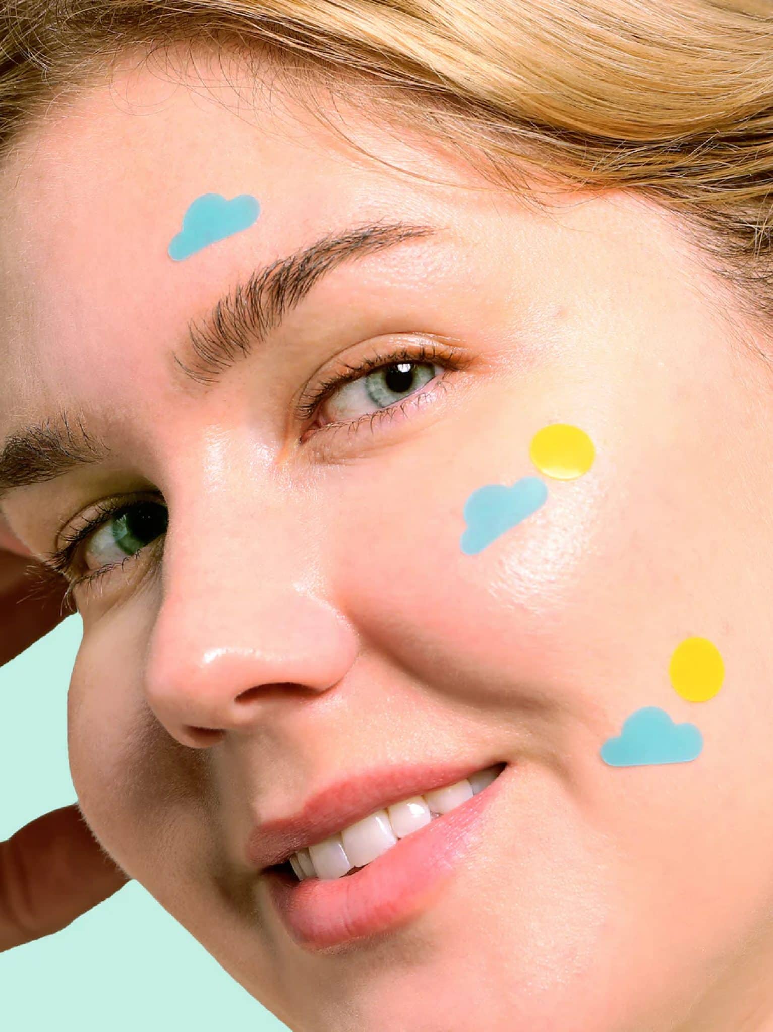 Girl wearing Rise & Shine Pimple Patches with sun and cloud shaped hydrocolloid acne patches on face