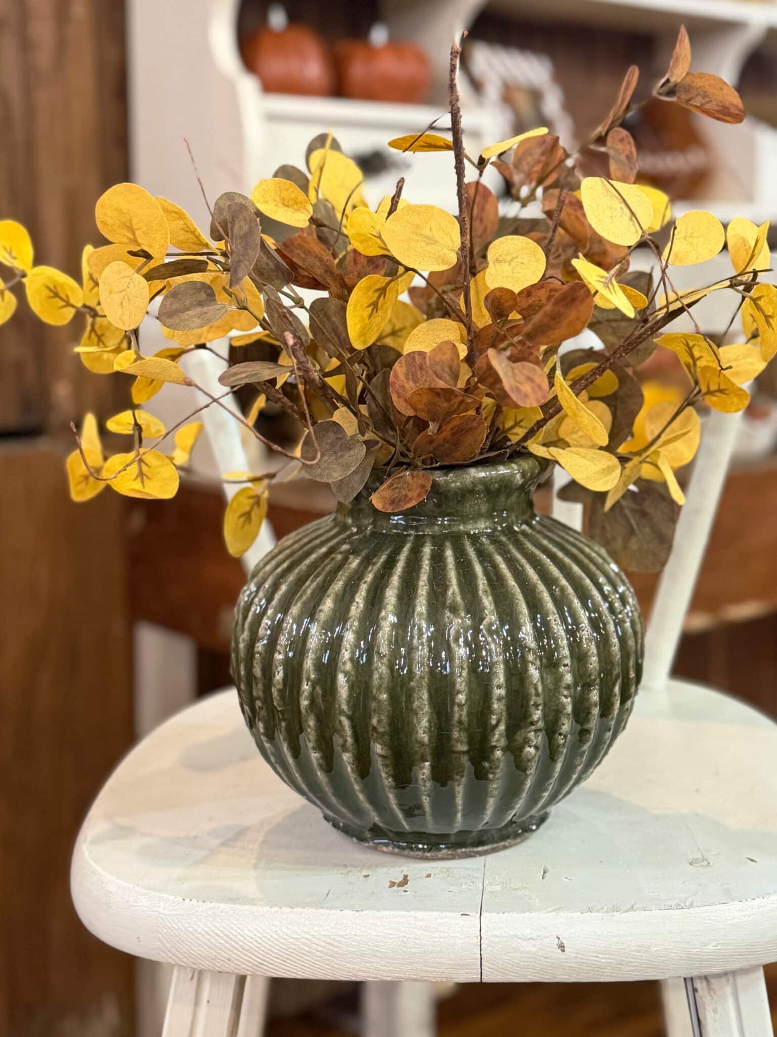 Ribbed Green Aged Terracotta Vase with mustard yellow eucalyptus and Brown Fall Leaf Sprays.